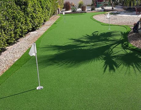 Close-up of flag hole on synthetic putting green - Putting greens, Dubai