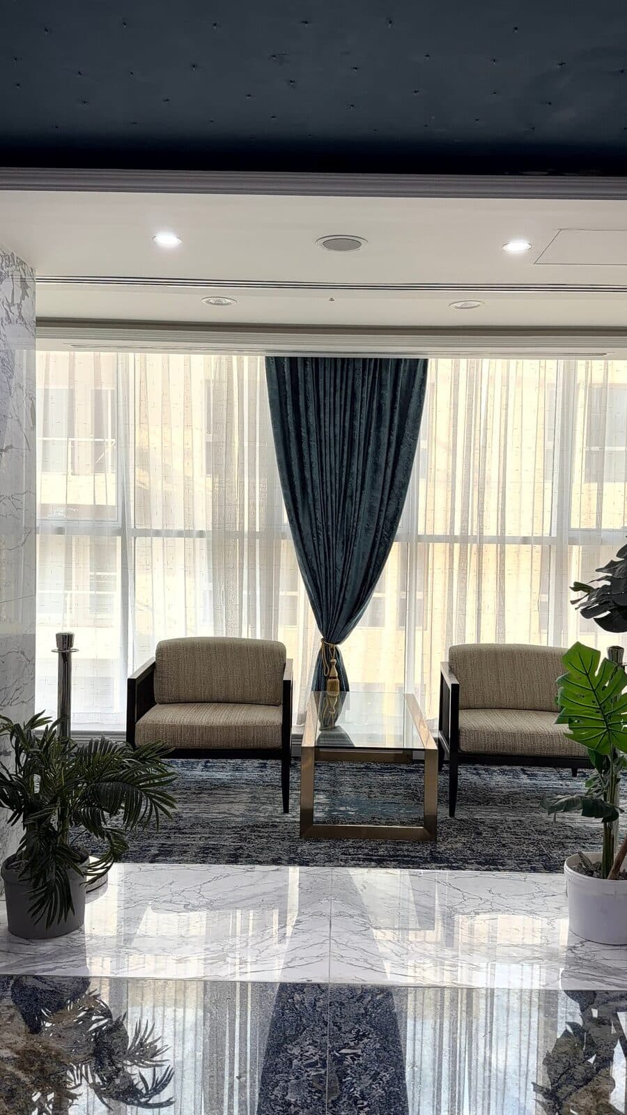 Formal sitting room with sheer curtains and a velvet drape
